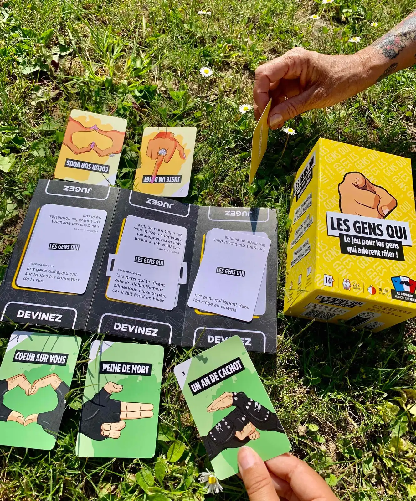 Partie de Les Gens Qui sur l'herbe au soleil : trois cartes sur le plateau du Juge et les cartes Mains vertes